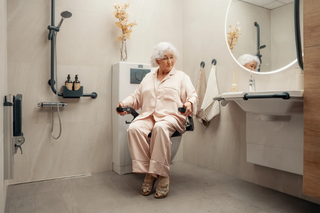 Eldre dame benytter Bano vendbart toalett. Toalettet er vendt mot dusjen.
