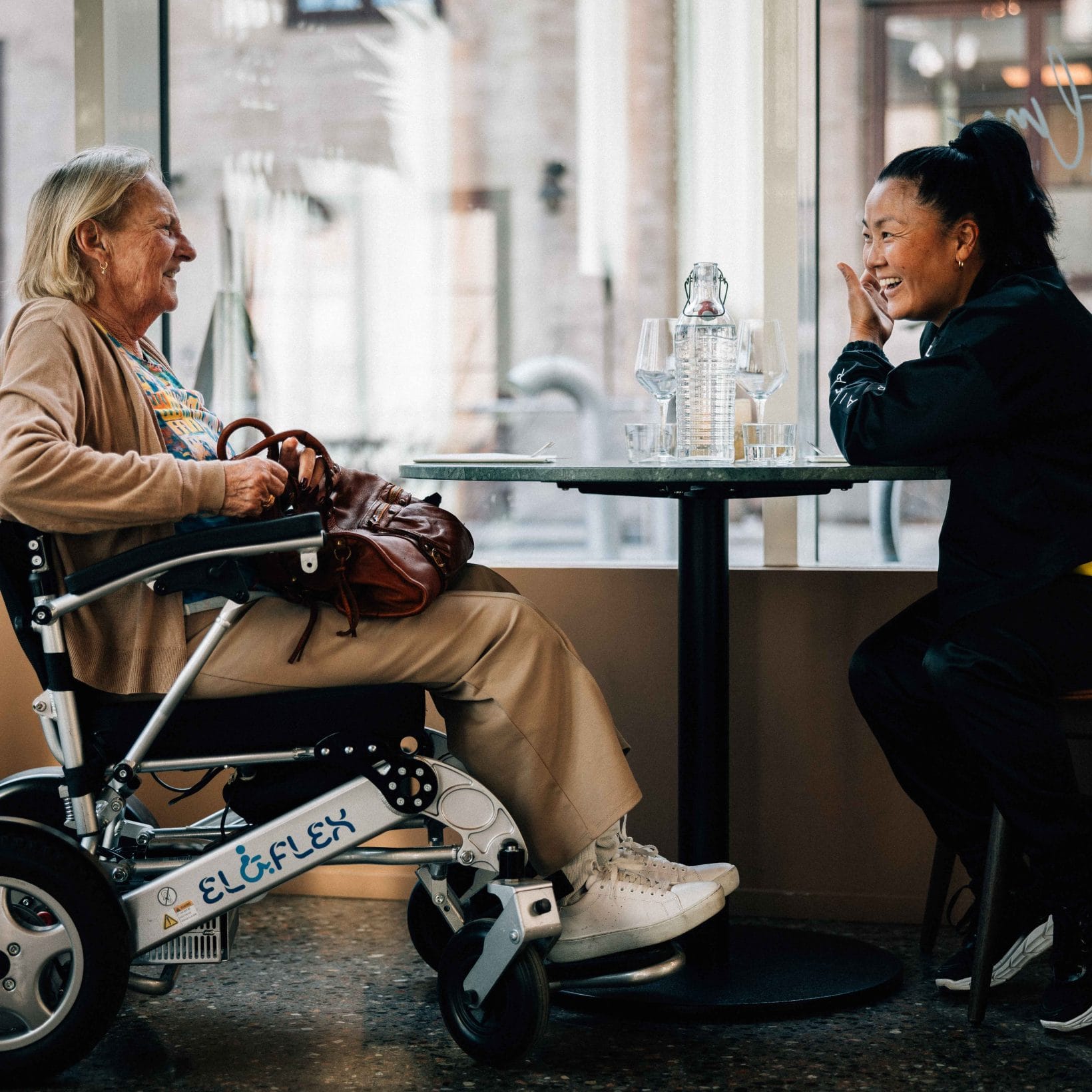 En dame i rullestol og venninne på kafe