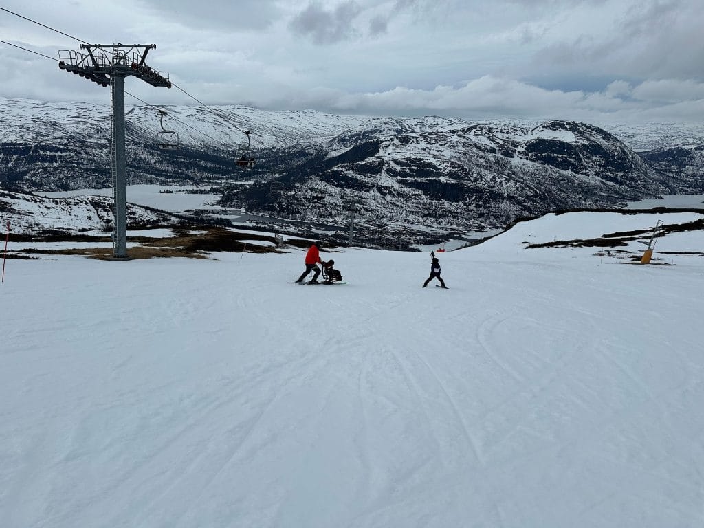 Sitskikjøring med far og datter i slalåmbakken.