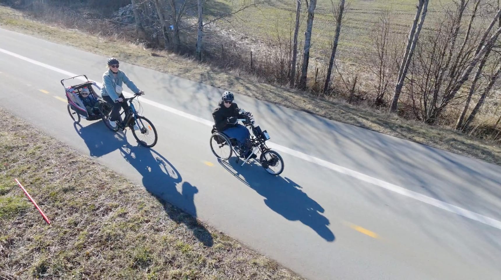 Jan Arne sykler sammen på en Stricker håndsykkel, mens kona sykler bak med en sykkelvogn.