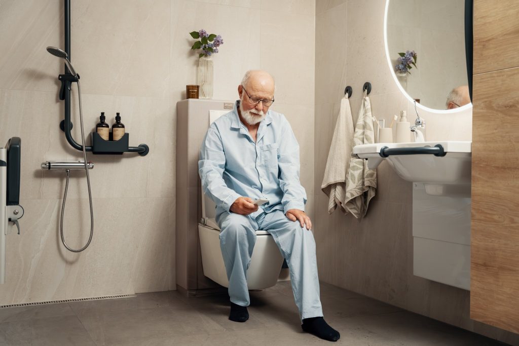 Jan på toalettet med fjernkontroll i hånda